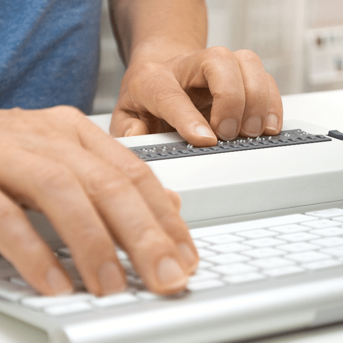 hands working on a keyboard with assistive technology