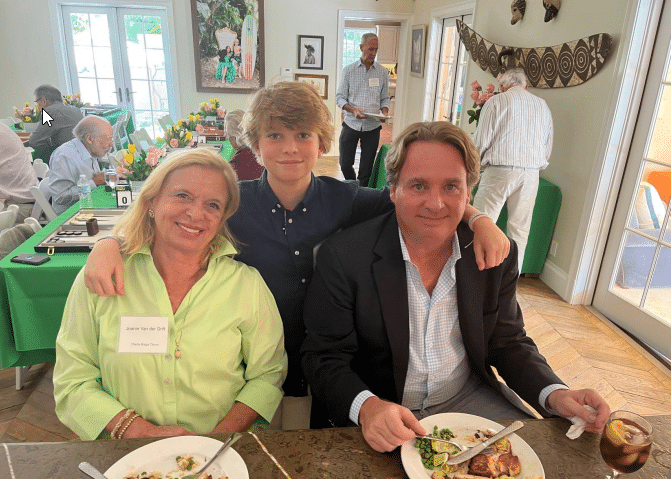 young boy stands with arms around senior woman and man