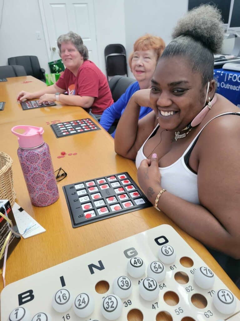 Three happy women with their bingo cards