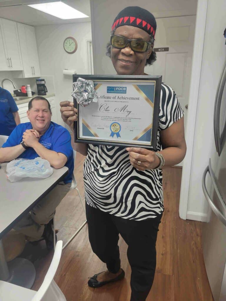 Cleo May holds graduation certificate