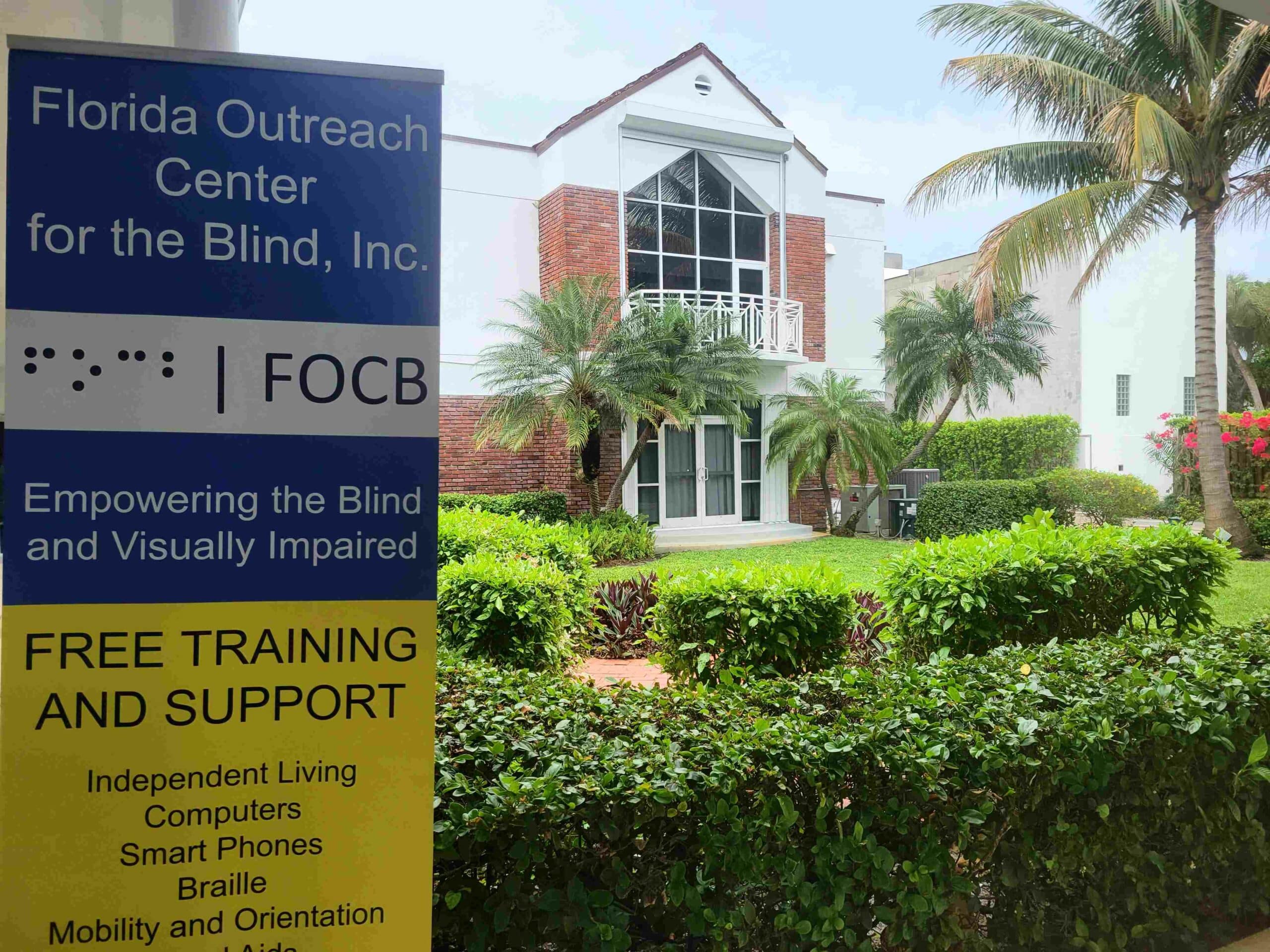 Exterior of the front of a building with a sign that reads, "Florida Outreach Center for the Blind"