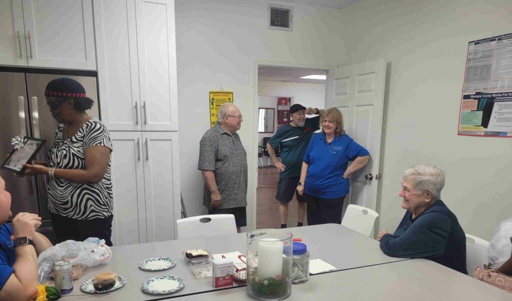 Three adults stand by table for a candid photo