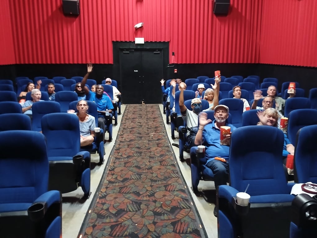 group of individuals sitting in a movie theatre with the lights on