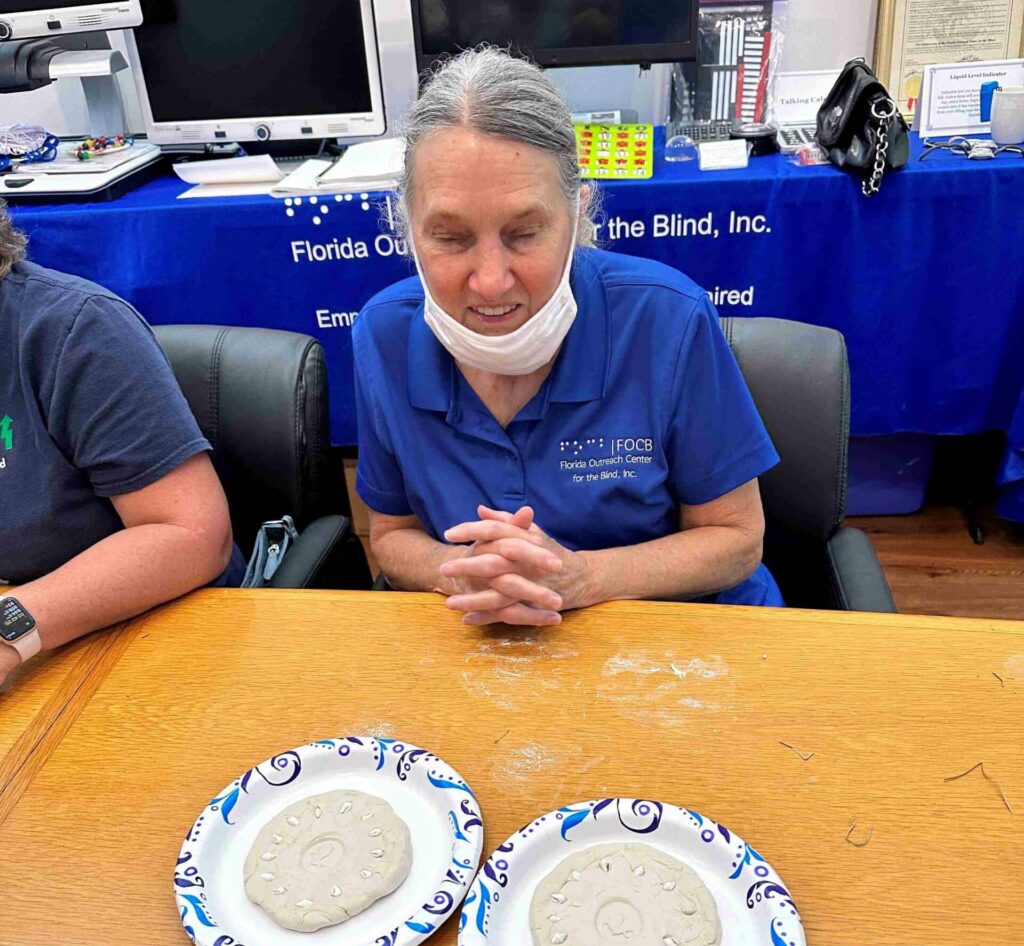 senior woman sits at table with two plates in front of her