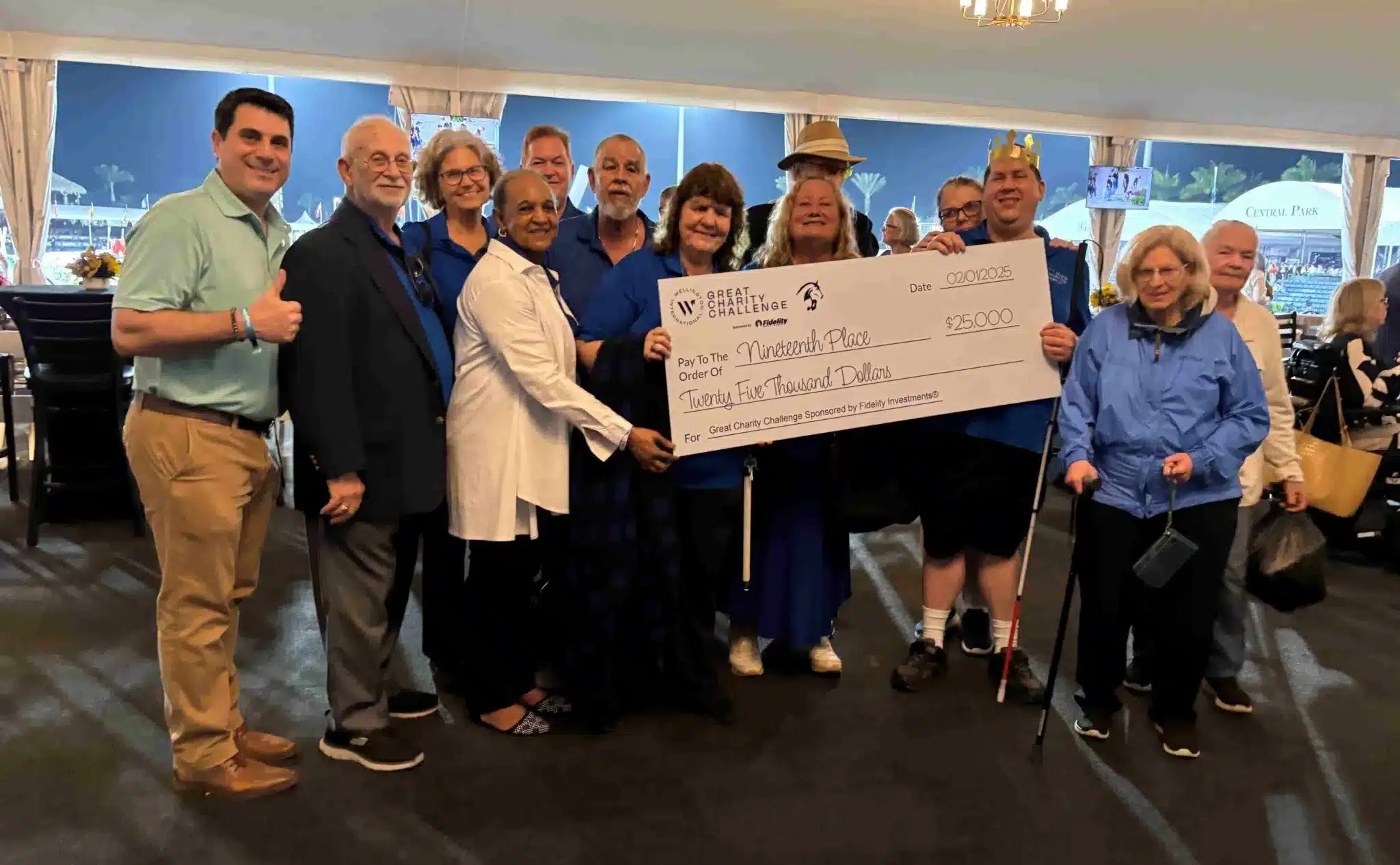 group of adults stand with large check for $25,000