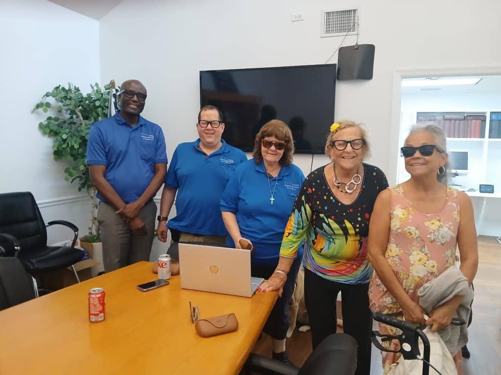 three adults in blue shorts stand with two women