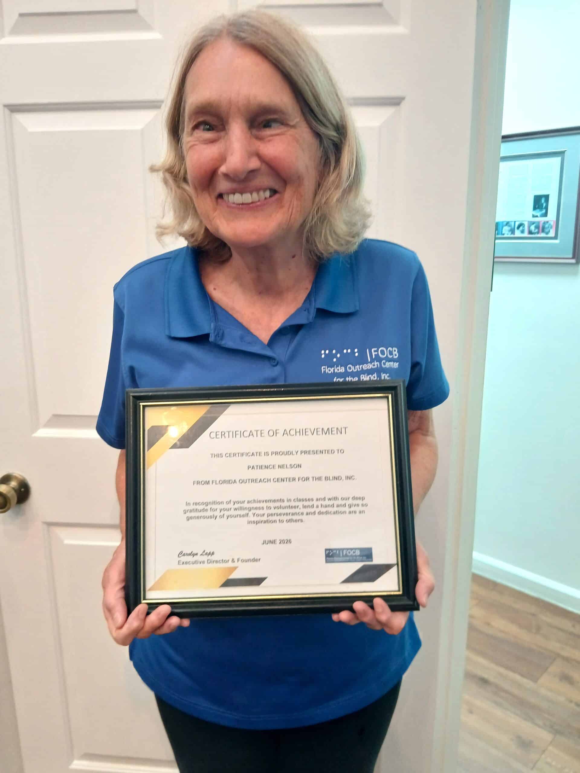 woman holds a framed certificate of achievement