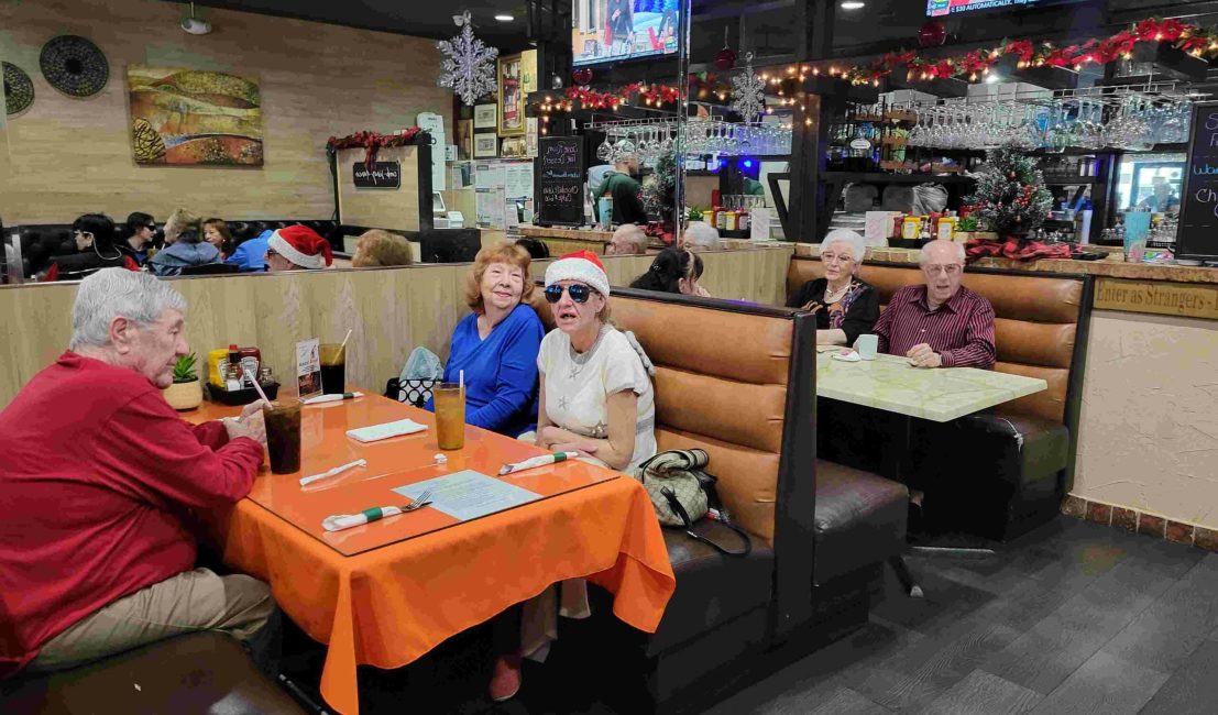 interior of restaurant with adults sitting in booths