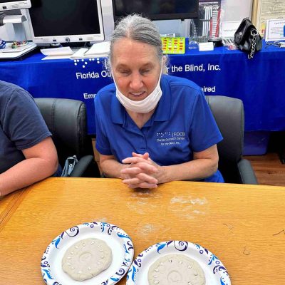senior woman sits at table with two plates in front of her
