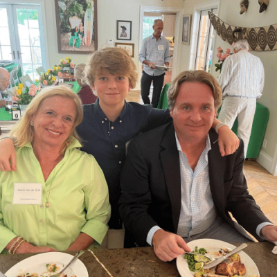 young boy stands with arms around senior woman and man