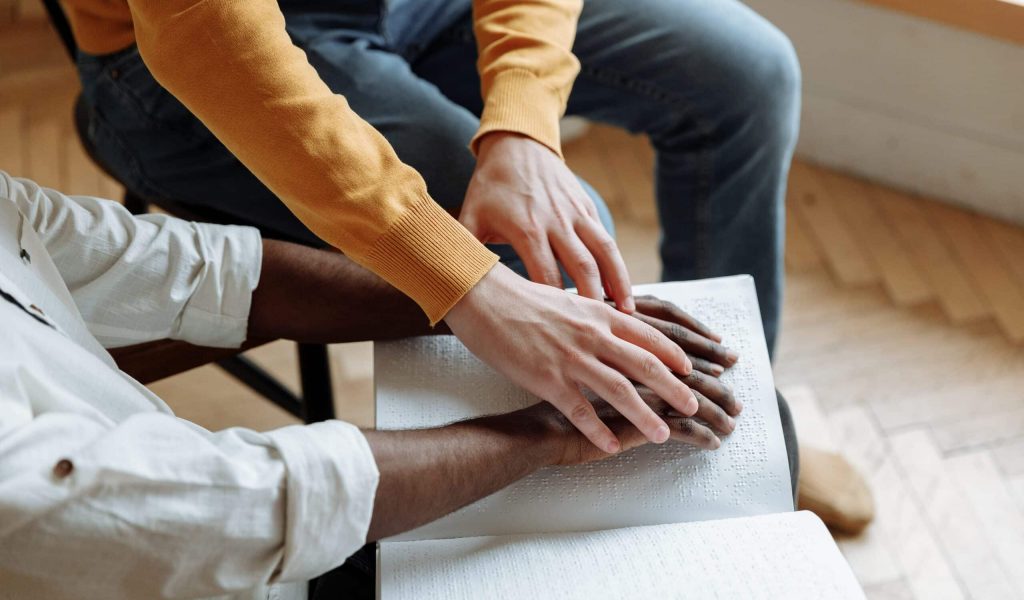 man learning to read braille